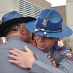 Former Jones County Deputy Bradley Boyd (in former MHP uniform) hugs his father.