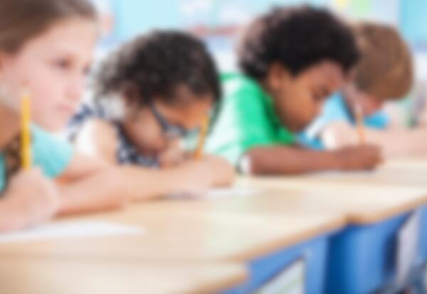 Blurred picture of children at a school desk working