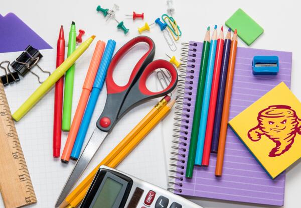 brightly colored school supplies. pile of pens, pencils, calculator, notebook, etc.